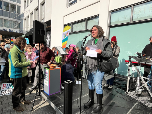 Redner*in Karin Racke auf der Kundgebung Senser Platz 15. Februar