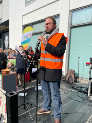 Redner*in Daniele Cipriano auf der Kundgebung Senser Platz 15. Februar