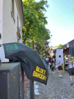 Bunt bespruehter Schirm mit der Aufschrift Bildet Banden