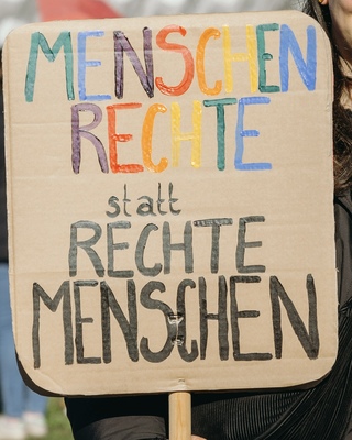 Demoschild mit der Aufschrift: Menschrechte statt Rechte Menschen