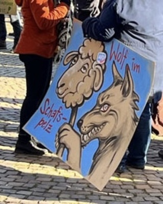 Demoschild mit der Aufschrift: Wolf im Schafspelz