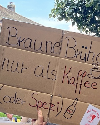 Demoschild mit der Aufschrift: Braune Bruehe nur als Kaffee (oder Spezi)