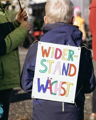 Kind mit einem Demoschild mit der Aufschrift: Widerstand waechst