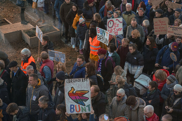 Eine Gruppe Menschen auf eine Demonstration. Sie halten Schilder hoch mit den Aufschriften 'Lörrach ist bunt', 'Bunt statt braun' und 'Es ist 5 vor 12'